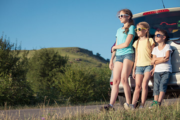 Image showing Happy brother and his two sisters are standing near the car at t