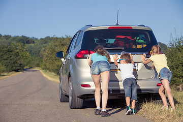 Image showing Happy brother and his two sisters are standing near the car at t