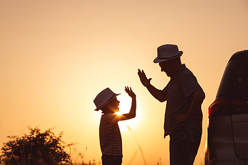 Image showing Father and son playing in the park at the sunset time.