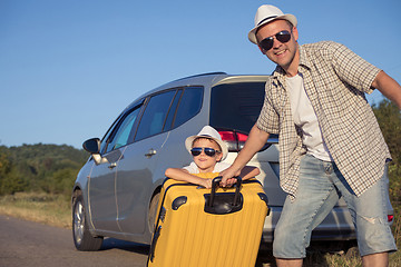 Image showing Happy father and son standing near the car at the day time.