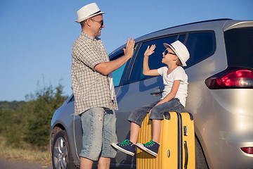 Image showing Happy father and son standing near the car at the day time.