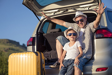 Image showing Happy father and son standing near the car at the day time.