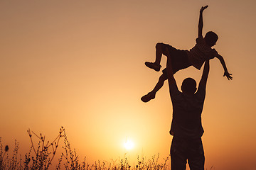 Image showing Father and son playing in the park at the sunset time.