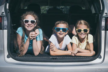 Image showing Happy brother and his two sisters are sitting in the car at the 