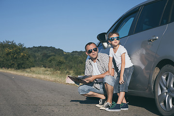 Image showing Happy father and son standing near the car at the day time.