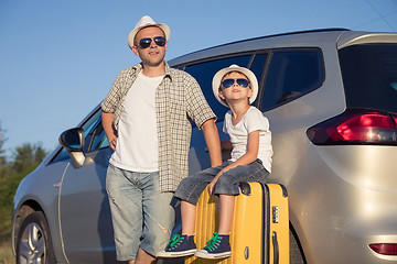 Image showing Happy father and son standing near the car at the day time.