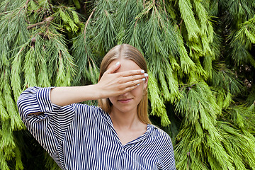 Image showing Woman wearing elegant clothes hiding her face standing in the fo