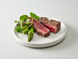 Image showing Plate of beef wagyu steak meat with herbs and asparagus