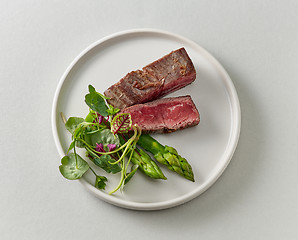 Image showing Plate of beef wagyu steak meat with herbs and asparagus