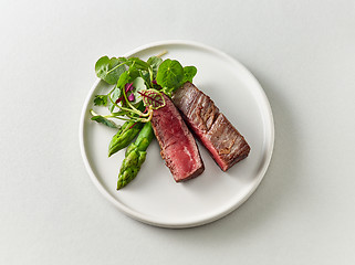 Image showing Plate of beef wagyu steak meat with herbs and asparagus