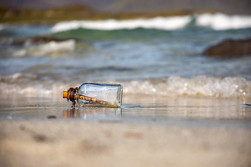 Image showing Message in the bottle against the Sun setting down