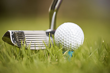 Image showing Golf ball on tee in front of driver