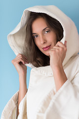 Image showing woman in a white coat with hood isolated on blue background