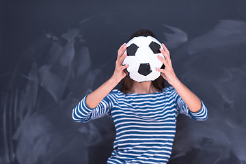 Image showing woman holding a soccer ball in front of chalk drawing board