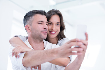 Image showing happy couple using mobile phone at home