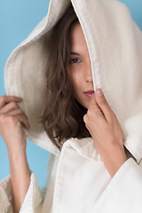 Image showing woman in a white coat with hood isolated on blue background