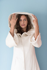 Image showing woman in a white coat with hood isolated on blue background