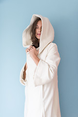 Image showing woman in a white coat with hood isolated on blue background