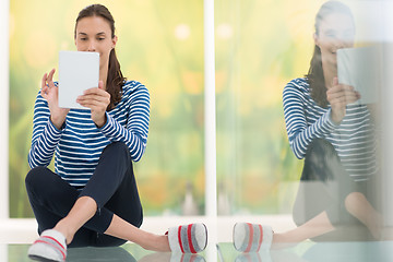 Image showing young women using tablet computer on the floor