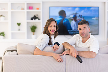 Image showing Young couple on the sofa watching television