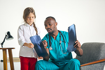 Image showing Young african male pediatrician explaining X-ray to child