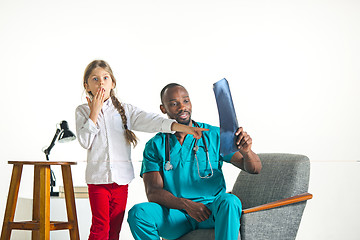 Image showing Young african male pediatrician explaining X-ray to child