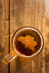 Image showing Belgian beer concept, Belgium silhouette on foam in beer glass on wooden table.