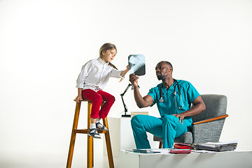 Image showing Young african male pediatrician explaining X-ray to child