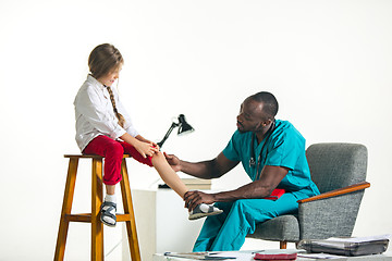 Image showing The afro male doctor doing neurology examination for little girl