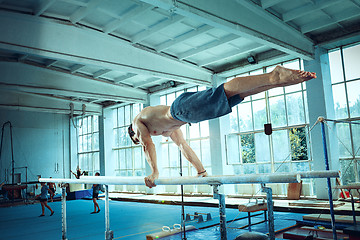 Image showing The sportsman during difficult exercise, sports gymnastics