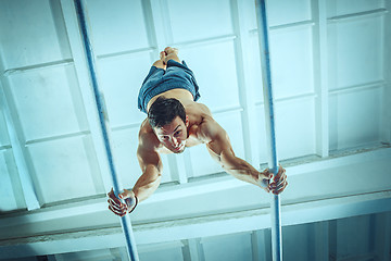 Image showing The sportsman during difficult exercise, sports gymnastics