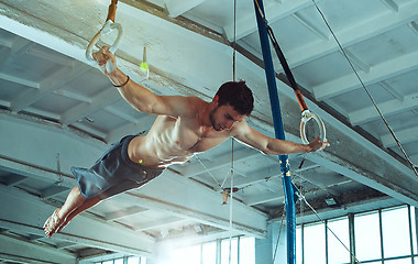 Image showing The sportsman during difficult exercise, sports gymnastics