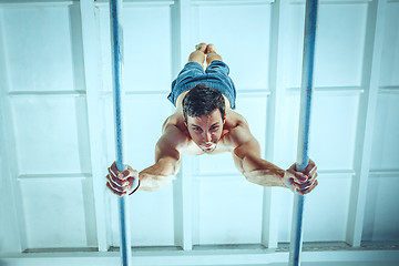 Image showing The sportsman during difficult exercise, sports gymnastics