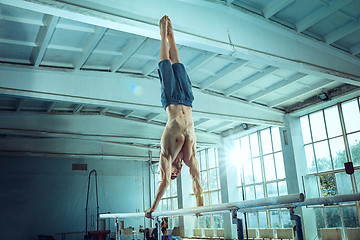 Image showing The sportsman during difficult exercise, sports gymnastics