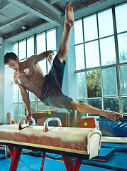 Image showing The sportsman during difficult exercise, sports gymnastics