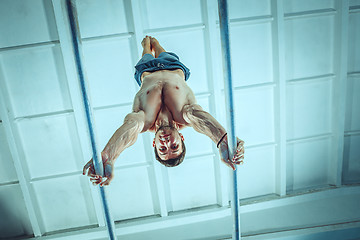 Image showing The sportsman during difficult exercise, sports gymnastics