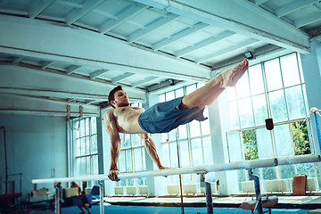 Image showing The sportsman during difficult exercise, sports gymnastics