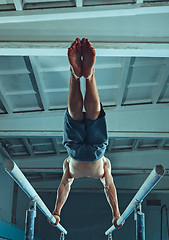 Image showing The sportsman during difficult exercise, sports gymnastics