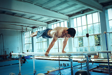 Image showing The sportsman during difficult exercise, sports gymnastics