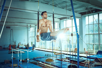 Image showing The sportsman during difficult exercise, sports gymnastics