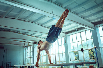 Image showing The sportsman during difficult exercise, sports gymnastics