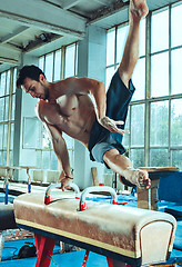 Image showing The sportsman during difficult exercise, sports gymnastics