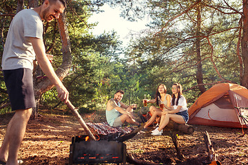 Image showing Party, camping of men and women group at forest. They relaxing