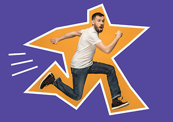 Image showing Freedom in moving. handsome young man jumping against orange background