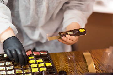 Image showing worker packing candies at confectionery shop