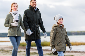 Image showing happy family walking along autumn beach