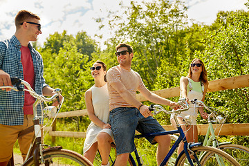 Image showing happy friends riding fixed gear bicycles in summer