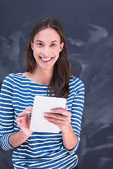 Image showing woman using tablet  in front of chalk drawing board