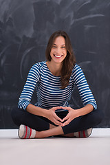 Image showing woman sitting in front of chalk drawing board