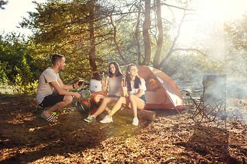 Image showing Party, camping of men and women group at forest. They relaxing